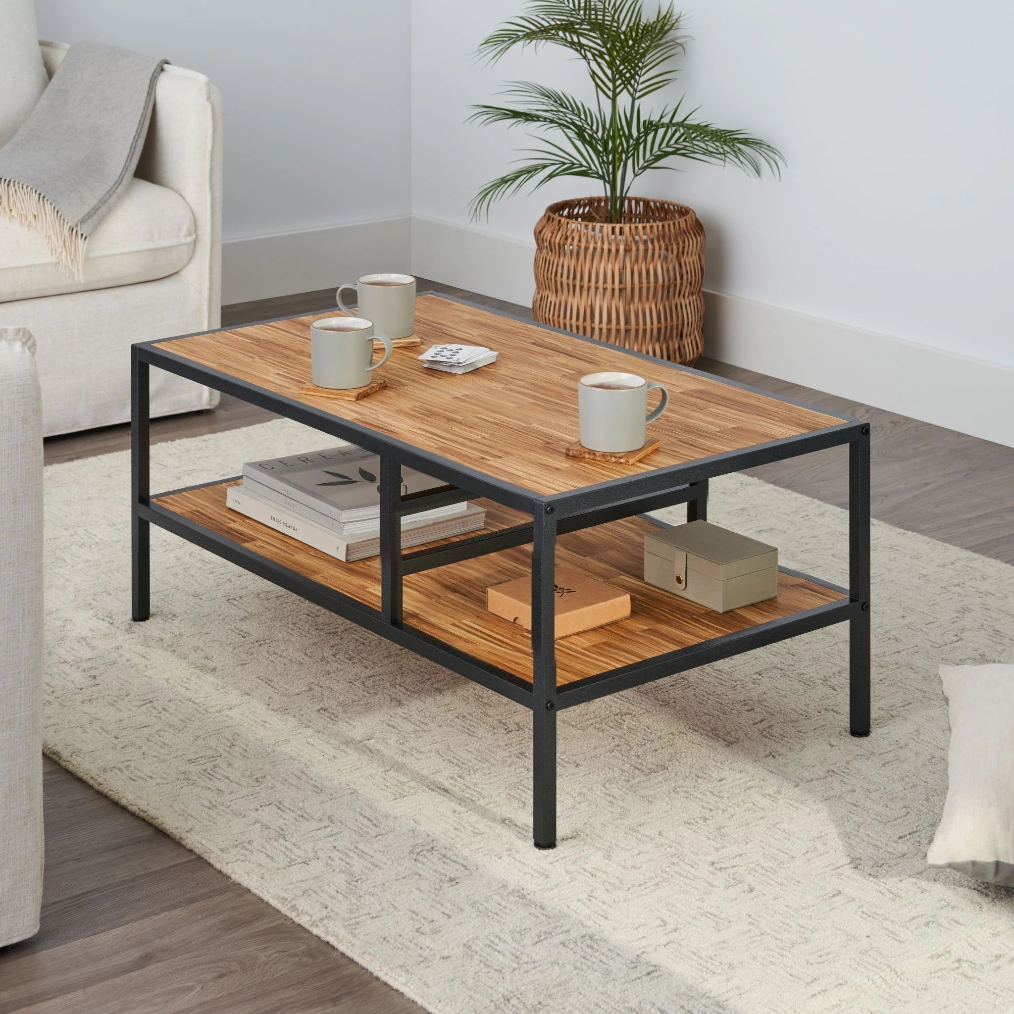 2 tier coffee table featuring chopstick made wood top and shelf placed in a living room with items on table top and shelf